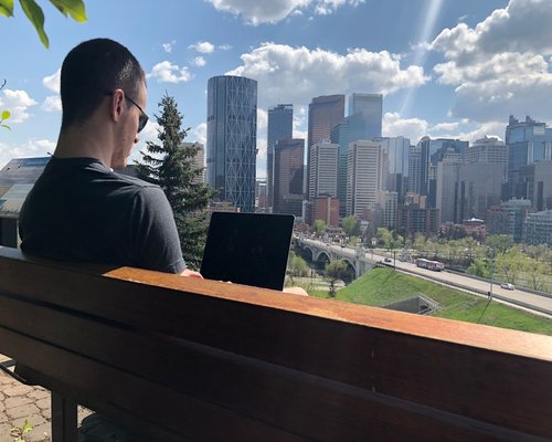 A person looking far away from their laptop towards the city view