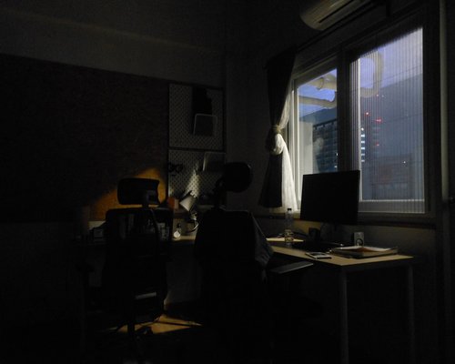 A well lit desk facing away from the direct sunlight window