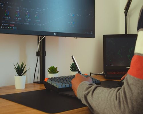 Person adjusting monitor settings in a modern home office